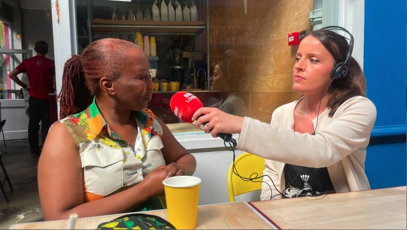 Community interview in Brixton — two people in conversation, one holding a microphone